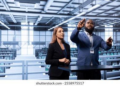 Coworkers using AR in data center, ensuring cybersecurity and efficient network management. Engineers in server hub optimizing data center equipment with augmented reality technology
