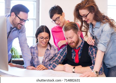 Coworkers working on project together in office - Shutterstock ID 714882631