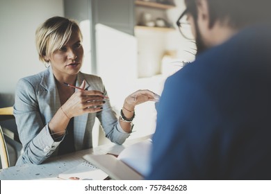 Coworkers working process at home.Young blonde woman working together with bearded colleague man at modern home office.People making conversation together.Blurred background.Horizontal - Shutterstock ID 757842628