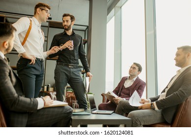 coworking of business team consisted of young successful men wearing formal suits, developing business projects together and discussing business partnership, interaction of diverse business people - Shutterstock ID 1620124081