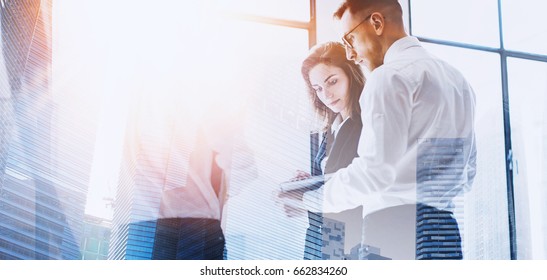 Coworking Team Meeting.Group Of Businessmans Working With Startup Project In Modern Office.Contemporary Laptop In Man Hands. Double Exposure,skyscraper Building Blurred Background.Flares Effect.Wide