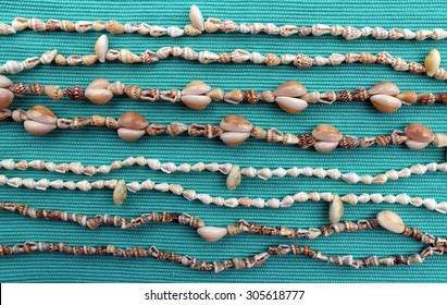 Cowrie Shell Necklaces On A Blue Background