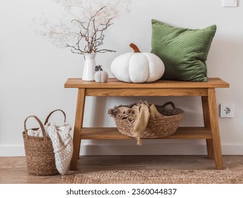 Cozy autumn interior in Scandinavian style - autumn decor, basket with blankets, pillows on an oak bench in the living room           - Powered by Shutterstock