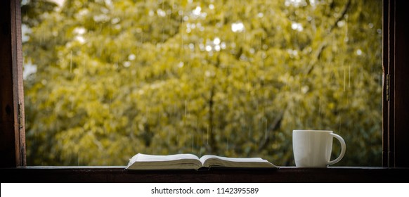 Cozy Autumn Still Life: Cup Of Hot Coffee And Opened Book On Vintage Windowsill And Rain Outside. Autumn. Apartment. Rain. 