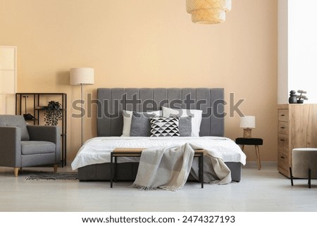 Cozy bed, chest of drawers and bedside bench in beautiful bedroom