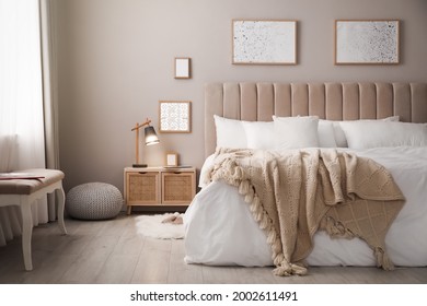 Cozy bed with soft linens in light room - Shutterstock ID 2002611491