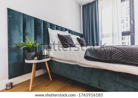 Cozy bedroom with comfortable bed in modern studio apartment. Interior design