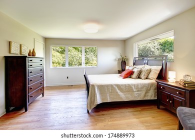 Cozy Bedroom With Hardwood Floor Furnished With Dark Brown Wood Furniture Set And Light Tones Bedding