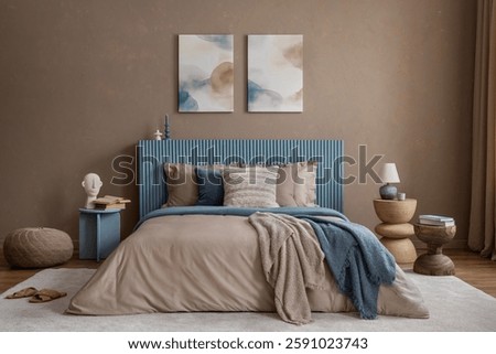A cozy bedroom with a ribbed blue headboard, layered textiles, and abstract wall art in soft, earthy tones.