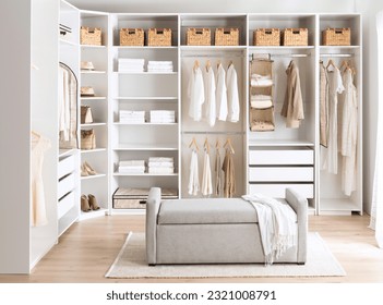 A cozy bedroom with white walls and a closet, featuring clothes hung up in neat fashion - Shutterstock ID 2321008791