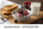 A cozy breakfast setting with a bowl of yogurt topped with mixed berries, a side of toast with butter, and a glass of milk