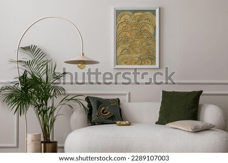 Cozy composition of living room interior with mock up poster frame, white sofa, green pillows, gold trace, plants, beige lamp, wall with stucco and personal accessories. Home decor. Template.