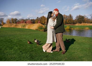 A cozy couple embraces warmly amidst autumn colors, enjoying a peaceful lakeside moment. - Powered by Shutterstock