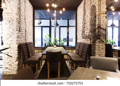 Cozy dining place at window, restaurant background. Beautiful and comfortable interior of cafe seat, copy space.