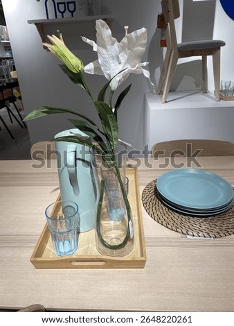 A cozy dining setup featuring a simple wooden table, a light blue jug, and plates. Perfect for a minimalist home decor or a quiet meal. #HomeDecor #DiningSetup #MinimalistStyle