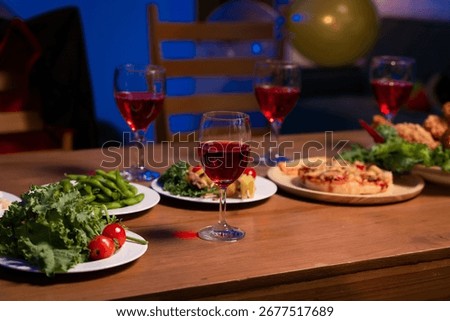 A cozy dinner table set with vibrant dishes, red wine glasses, and warm lighting, symbolizing togetherness, comfort, and the joy of sharing delicious food in a relaxed, festive atmosphere, no people.