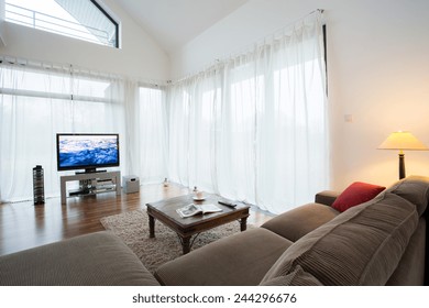 Cozy drawing room with comortable sofa and television