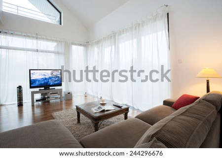 Cozy drawing room with comortable sofa and television