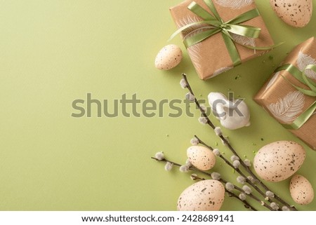 Cozy Easter arrangement concept. Top view of handcrafted gift wrappings, bunny ornament, quail eggs with natural markings, pastry sprinkles, pussy willow stems, green background with vacant space