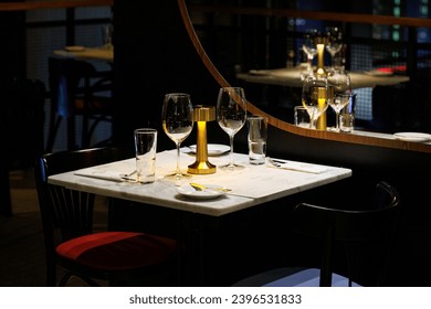 A cozy and elegant table setting for a romantic dinner in a dimly lit restaurant.
