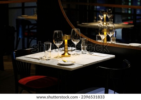 A cozy and elegant table setting for a romantic dinner in a dimly lit restaurant.