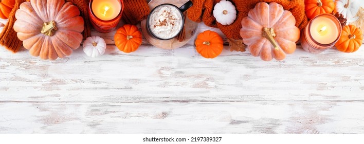 Cozy Fall Top Border With Pumpkins, Leaves, Sweater And Pumpkin Spice Drink. Overhead View Over A Rustic White Wood Banner Background.