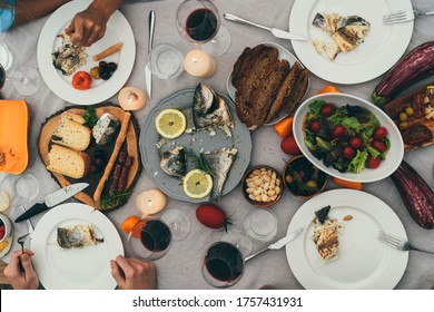 Cozy Family Dinner By Candles Outside, Top View Of Served Dinner Table With Healthy Mediterranean Food, Fish, Vegetables And Snacks, Group Of People In Restaurant Having Great Time At Dinner Party