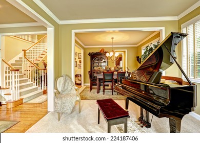 Cozy family room interior in luxury house. Room with grand piano. Dining area and white staircase