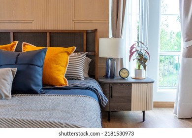 Cozy Furnished Bedroom An Accent Of Blue And Yellow Pillow. Room Furniture With Table Lamp And Carpet.