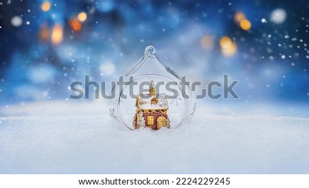  Cozy gingerbread house in christmas bauble over snowy background with copy space 