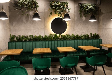 A cozy green-themed café interior featuring unique lighting and lush plants for a relaxing dining experience - Powered by Shutterstock