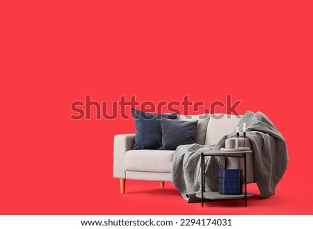 Cozy grey sofa and coffee table on red background