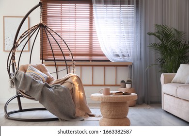 Cozy Hanging Chair With Fairy Lights In Modern Living Room. Interior Design