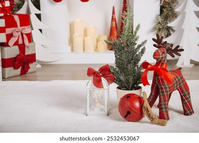 Cozy holiday decor featuring a plaid reindeer with red bow, white lantern, mini Christmas tree, and red bell, all placed in a festive living room setting. - Powered by Shutterstock