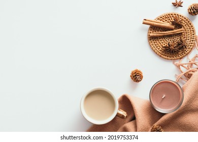 Cozy home desk table with plaid, coffee cup, candle on white background. Top view, flat lay, copy space. Autumn composition. Nordic hygge style concept.