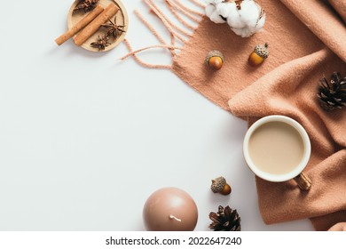 Cozy Home Desk Table With Scarf, Coffee Cup, Cotton, Pine Cones, Cinnamon Sticks On White. Flat Lay, Top View, Copy Space