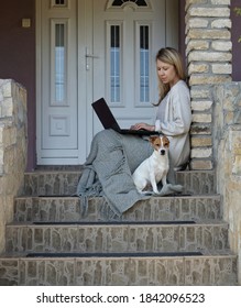 Cozy Home, Dog Sitting Next To Woman Using Laptop , Sitting On Steps On A Front Porch. Carefree, Comfort Lifestyle.