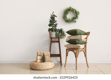 Cozy home interior with decorative pillows on chair, mini Christmas tree and mistletoe wreath - Powered by Shutterstock