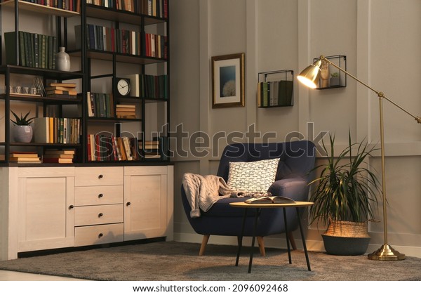 Cozy home library\
interior with collection of different books on shelves and\
comfortable place for\
reading