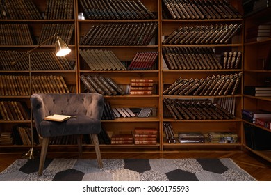 Cozy Home Library Interior With Comfortable Armchair And Collection Of Vintage Books On Shelves