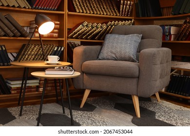 Cozy Home Library Interior With Comfortable Armchair And Collection Of Vintage Books On Shelves