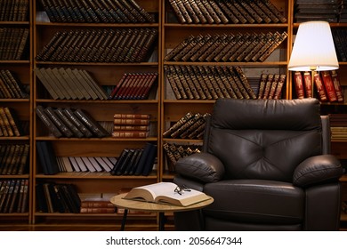 Cozy Home Library Interior With Leather Armchair And Collection Of Vintage Books On Shelves