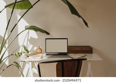 Cozy Home Office with Laptop, Notepad, and Plant in Sunlit Room - Powered by Shutterstock