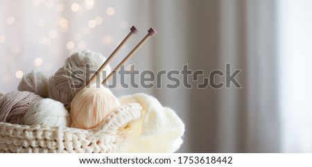 Cozy homely atmosphere. Female hobby knitting. Yarn in warm colors. Pink, peach, beige, white and green. The beginning of the process of knitting a women's sweater.