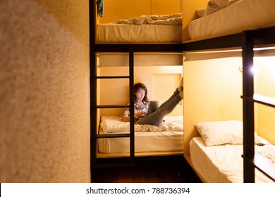 Cozy Hostel For Students. Young Cute Girl Looking At Laptop Lying On Her Bed At Hostel For Young People And Prepare For Examination At University