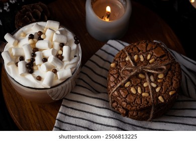 Cozy hot chocolate with marshmallows and a chocolate chip cookie tied with twine, candlelit setting, inviting warm ambience. - Powered by Shutterstock