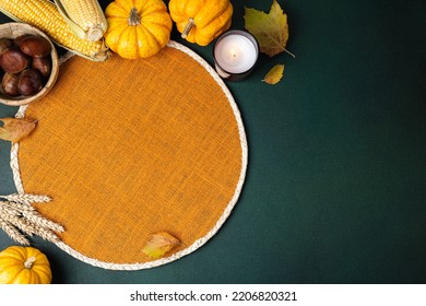 Cozy Hygge Table. Top View Of Wicker Place Mat, Pumpkins, Autumn Leaves, Candle On Dark Table. Autumn Table Setting. Festive Thanksgiving Background. Restaurant Menu. Copy Space
