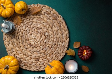 Cozy Hygge Table. Top View Of Wicker Place Mat, Pumpkins, Autumn Leaves, Candle On Dark Table. Autumn Table Setting. Festive Thanksgiving Background. Restaurant Menu. Copy Space
