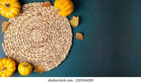 Cozy Hygge Table. Top View Of Wicker Place Mat, Pumpkins, Autumn Leaves, Candle On Dark Table. Autumn Table Setting. Festive Thanksgiving Background. Restaurant Menu. Copy Space
