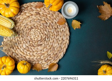 Cozy Hygge Table. Top View Of Wicker Place Mat, Pumpkins, Autumn Leaves, Candle On Dark Table. Autumn Table Setting. Festive Thanksgiving Background. Restaurant Menu. Copy Space
